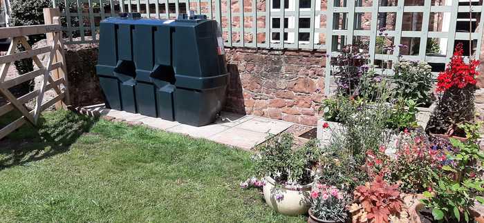 oil tank behind brick wall and trellising 